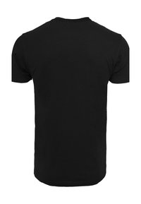 Camiseta de algodón negra con cuello redondo clásico, mangas cortas y dobladillo recto. Textura suave, sin patrones o acentos visibles.