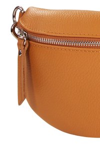 Oranje leren pouch met een afgeronde vorm, voorzien van een metalen rits en een leren label. Het gestructureerde oppervlak voegt een tastbaar detail toe.