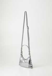 Silver sequin shoulder bag with a curved design, detachable gray strap, and a small handle. Surface features a shiny, textured finish.