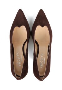 Para brązowych zamszowych balerinek damskich z ostro zakończonym noskiem, z beżowymi wkładkami i srebrnym logo "Hegos Milano" wewnątrz, na białym tle.