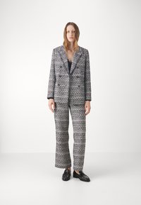 Skreddersydd blazer og bukse sett i et vevd stoff, med et mørkeblått og hvitt mønster, notched krage og straight-leg passform.