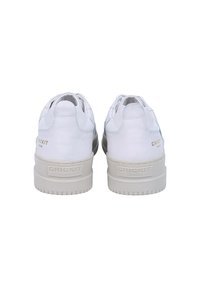 Hvide lædersneakers med en struktureret overflade, der har en tyk, beige gummisål og prægede mærkenavn på hælen.