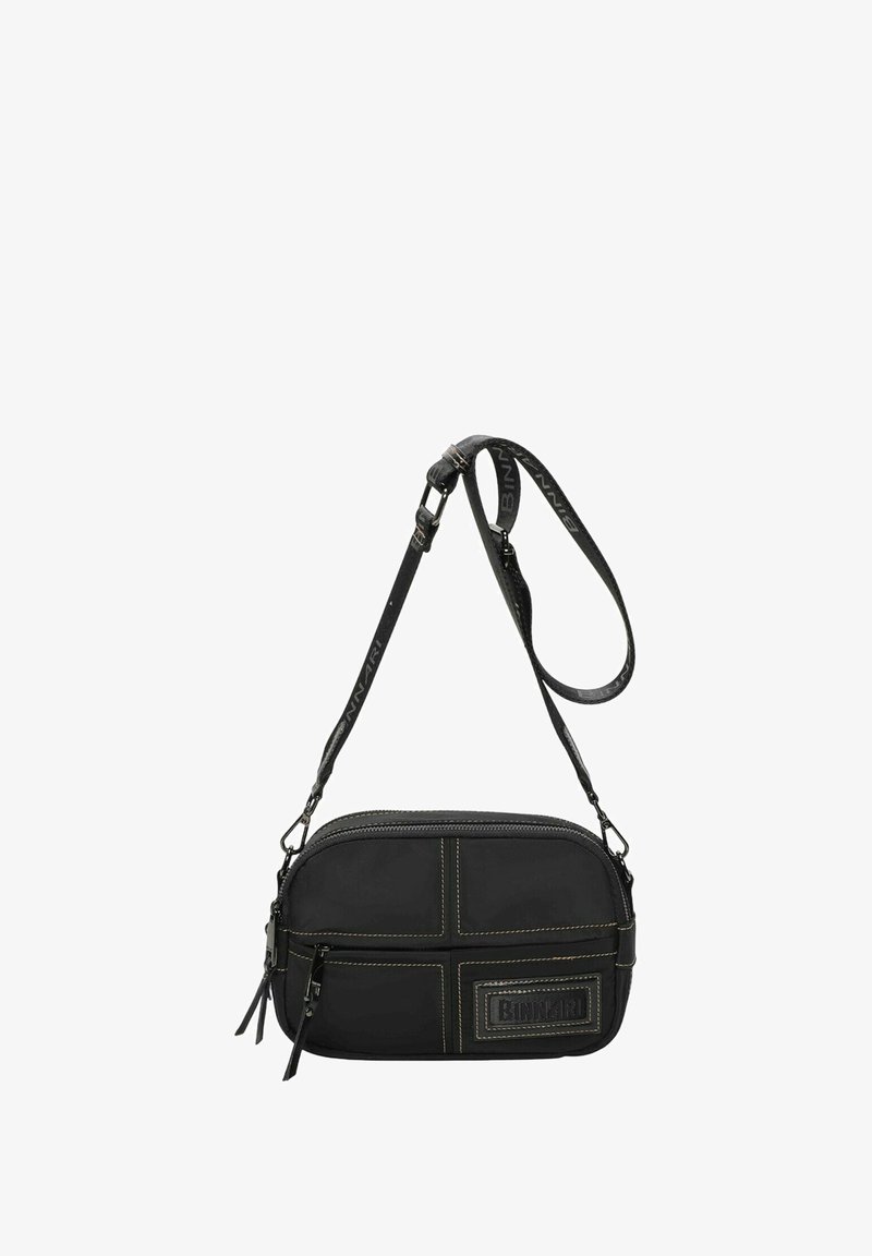 Bolso bandolera negro fabricado en tela con costuras amarillas en contraste. Presenta un cierre de cremallera, una correa ajustable y un parche con el logo en la parte frontal.