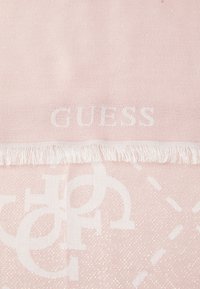 Roosa kohev sall, millel on peen sära, fringe servad ja embosed "GUESS" logo, koos tekstuurilise mustriga, mis kujutab omavahel seotud tähti.