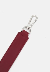 Burgundin värinen synteettisestä nahasta valmistettu hihna, jossa on sileä pinta, hopeinen metallinen kääntöklipsi sekä suorakaiteen muotoiset päätyosat, joissa on ompeluDETAIL.