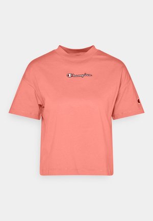 Koraalroze cropped Champion T-shirt met korte mouwen en logo geborduurd op borst en linker mouw.