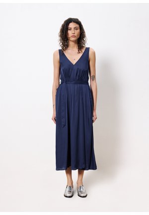 Navy blue, sleeveless dress with a V-neck, cinched waist, and flowing skirt. Features a smooth texture and ties at the waist for adjustment.