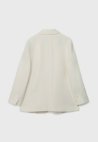 Kremowa marynarka o strukturalnym fasonie, z wykładanym kołnierzem, długimi rękawami i subtelnymi guzikami przy mankietach.