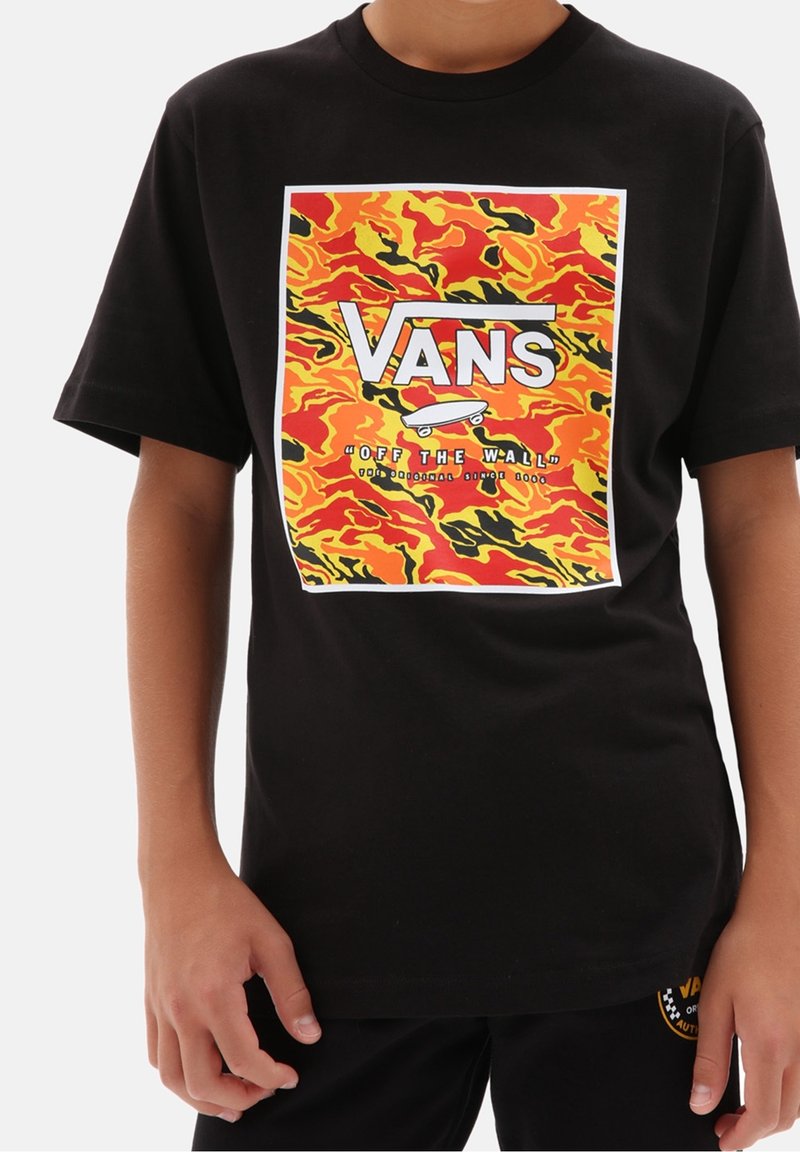 T-shirt Vans noir avec un motif carré de flammes rouges, oranges, jaunes et noires, et un logo Vans blanc avec skateboard et texte "Off the Wall".