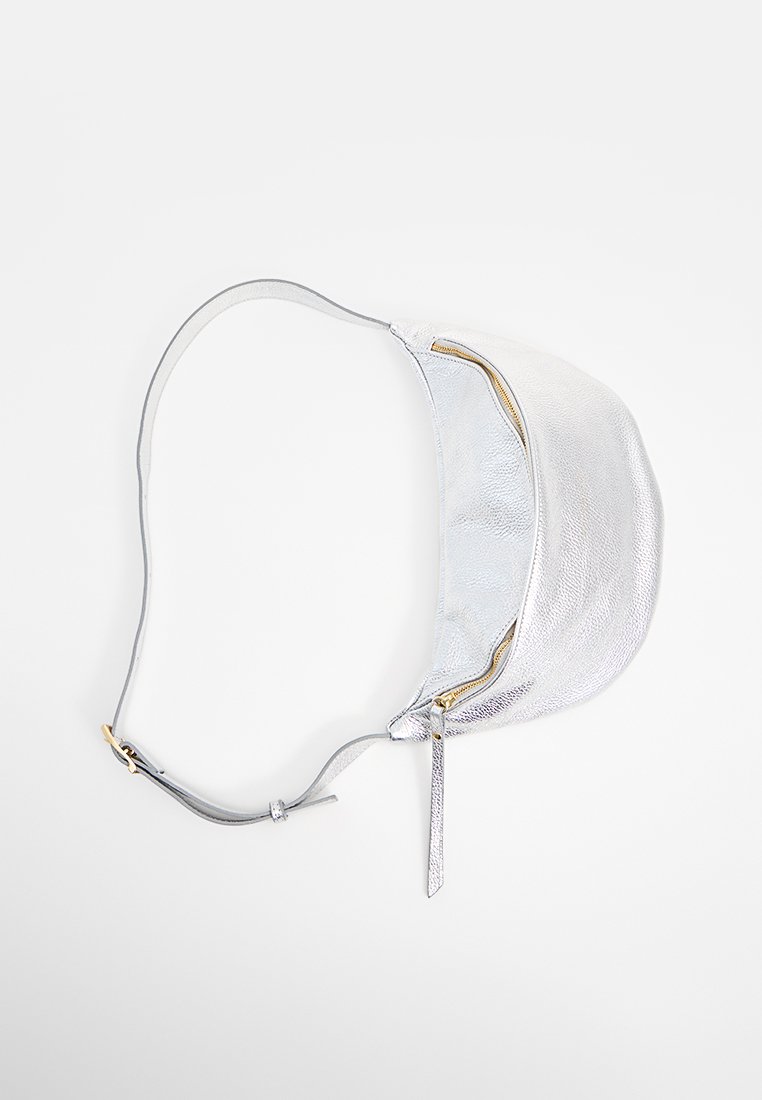Silberne Leder-Schultertasche mit glatter Textur, konturiertem Design und einem einzigen Reißverschluss. Verstellbarer Gurt mit goldfarbenen Akzenten.