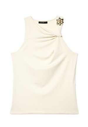 Ärmelloses cremefarbenes Top mit drapiertem Detail auf der Brust und einer goldenen Blumenbrosche auf der rechten Schulter.