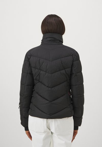 Μαύρο θερμικό μπουφάν με ψηλό γιακά, λεπτομέρειες ραφής σε σχήμα ζιγκ-ζαγκ και ελαστικούς καρπούς. Λείο ύφασμα με ματ φινίρισμα.