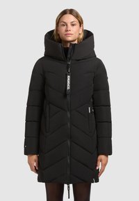 Zwarte pufferjas met een hoge, opgevouwen capuchon, chevron-quilt ontwerp, voorrits en logo-label aan de rits, met zijzakken.