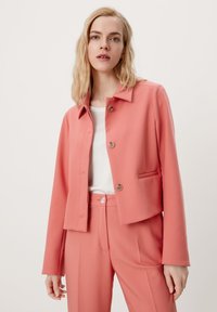 Koraalroze cropped jacket met een rechte snit, knoopsluiting en zijzakken, gecombineerd met bijpassende op maat gemaakte broek. Gladde stof.