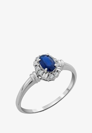 Bague en argent avec un centre en saphir bleu ovale entouré de pierres claires rondes, un bandeau lisse et des accents décoratifs.