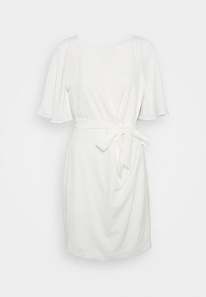 Robe blanche mi-genou avec manches courtes volantées et ceinture nouée à la taille, présentée sur un fond uni.