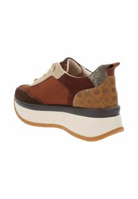 Zapatilla marrón y beige con una parte superior de ante y cuero texturizado, con perfil bajo, cierre de cordones, tirador en el talón con brillo y una suela gruesa blanca.