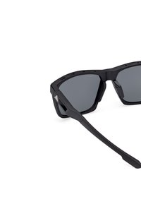Ochelari de soare sport negri, fabricați din plastic durabil, cu lentile gri, design al ramei unghiular și o prindere texturată pe laterale.