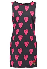 Robe noire sans manches avec des motifs de cœurs roses partout et un petit motif de lèvres rouges avec le mot "Desigual" près de l'ourlet inférieur.