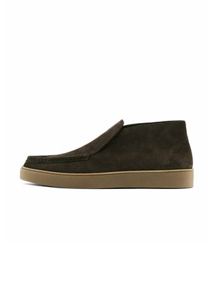 Bruine suede instappers met een gladde afwerking, ronde neus en een lichtbruine rubberen zool. Bovenkant heeft een eenvoudig, strak design.