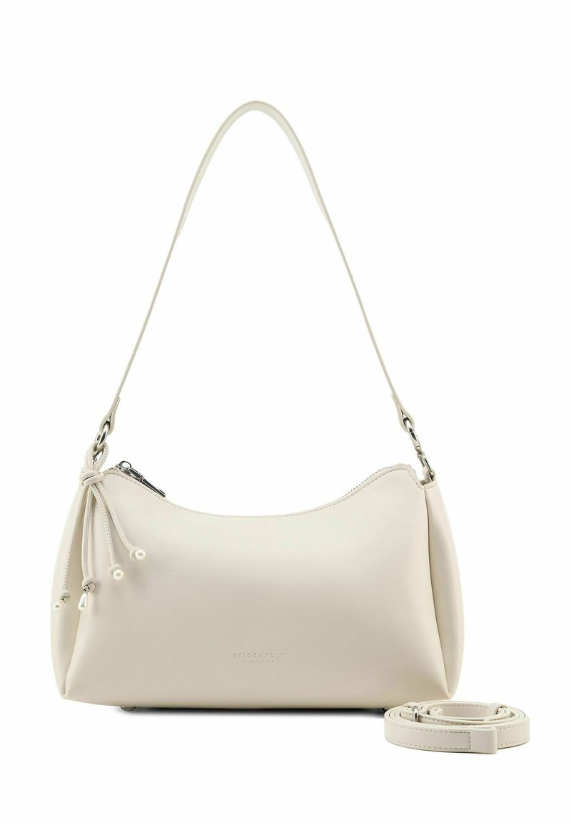 Borsa a mano in pelle color crema con forma curva, chiusura con cerniera e tracolla removibile. Presenta un cordoncino decorativo con dettagli a perline.