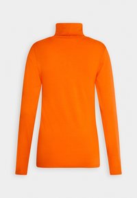 Chemise à col roulé orange vif à manches longues vue de dos sur un fond uni clair.