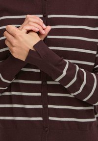 Maroon striped cardigan with gray stripes, featuring a button-up front and ribbed cuffs. Soft, lightweight material and relaxed fit.