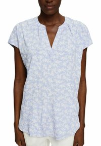 Blusa floreale azzurro chiaro con maniche corte, scollatura a V, tessuto morbido, sottile motivo floreale bianco e vestibilità ampia per il comfort.