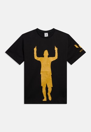 Crna majica s velikim zlatnim siluetom osobe koja podiže oba kažiprsta prema gore i zlatnim logotipom “MESSI” na desnom rukavu.