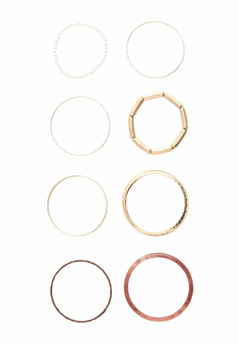 Nine rings displayed: a beaded white ring, four gold-tone rings with varied textures, a red ring, and a hammered gold ring.