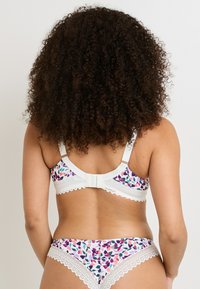 Reggiseno a stampa floreale e mutandine abbinati con rifinitura in pizzo bianco. Il reggiseno presenta spalline regolabili e una chiusura con ganci e occhielli sul retro.