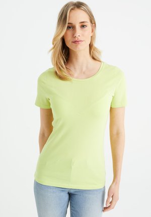 T-shirt verde chiaro a maniche corte con scollo rotondo, texture morbida e silhouette aderente. Abbinato a jeans blu.