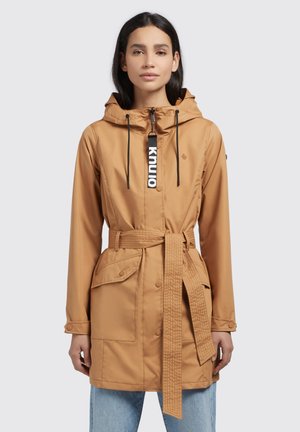 Tan waterproof jacket with a hood, belted waist, two front pockets, zipper closure, and contrasting label detail on the zipper.