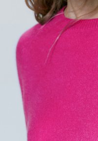 Pull fuchsia à col rond et col côtelé ; présente une texture douce en tricot fin et un design ajusté.