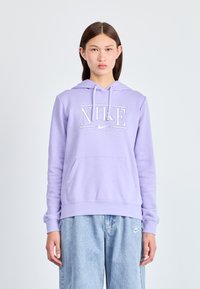 Haut à capuche violet clair avec une poche kangourou, arborant un logo Nike blanc et un design de texte. Matière 100 % coton avec une capuche réglable par cordon.