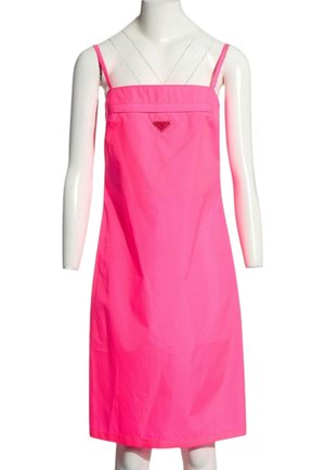 Hellpinkes ärmelloses knielanges Kleid mit dünnen Trägern und einem kleinen dreieckigen Logo auf der Brust, präsentiert auf einer weißen Schaufensterpuppe.