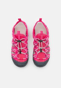 Pink water shoes with stretchy fabric upper and adjustable bungee laces, featuring a textured black rubber sole and patterned accents.