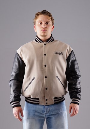Beige wool-blend varsity jacket with black leather sleeves, ribbed cuffs, and "Picaldi Sport" logo. Two side pockets with dark accents.