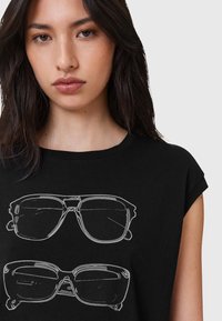 Schwarzes ärmelloses T-Shirt mit einer weißen Grafik von zwei Paar Sonnenbrillen, die jeweils unterschiedliche Formen und Details auf der Vorderseite aufweisen.