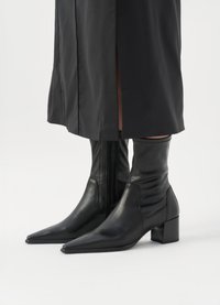 Botine negre din piele cu vârf ascuțit, închidere cu fermoar și toc gros. Textură netedă cu detalii pliate la gleznă.