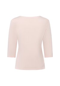 Top rosa chiaro a tre quarti con maniche, realizzato in morbido cotone, con scollatura ampia e orlo leggermente curvo.