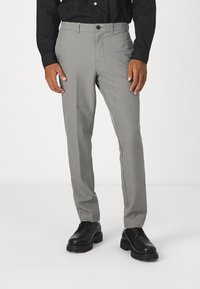 Grå skräddarsydda byxor i ett lättviktigt material, med slim fit, slät front och en enkel knappstängning, i kombination med svarta skor.