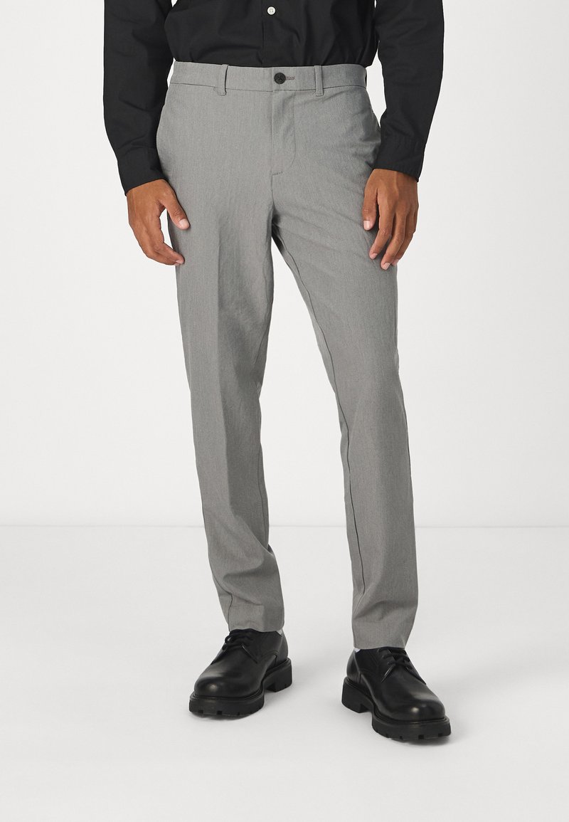 Grå skräddarsydda byxor i ett lättviktigt material, med slim fit, slät front och en enkel knappstängning, i kombination med svarta skor.