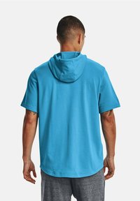 Krátký rukáv mikina s kapucí v jasně modré látce, se šňůrkovou kapucí, hladkou texturou a pohodlným střihem, nošená s šedými šortkami.