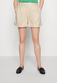 Béžové pruhované šortky s plisovaným designem a ohrnutým lemem. Mají boční kapsy a zapínání na knoflík. V kombinaci s černými mokasínami.