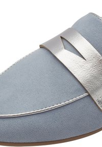 Lichtblauwe suede schoen met een metallic zilveren band en een uitsnijontwerp. Witte stiksels langs de rand en een ronde neus.