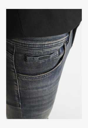 Donkerblauwe denim jeans met een slim fit, met subtiele vervaging, een label op de achterzak en klassieke stiksels.