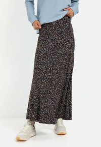 Maxi-nederdel i mørk base med spredt blå og beige blomsterdesign. Har et svævende design og blødt stof. Kombineret med hvide sneakers.