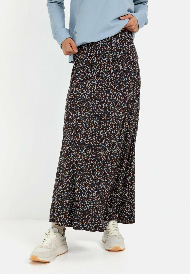 Maxi-nederdel i mørk base med spredt blå og beige blomsterdesign. Har et svævende design og blødt stof. Kombineret med hvide sneakers.