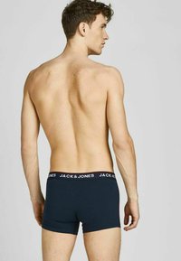 Marineblaue Boxershorts mit einem kontrastierenden schwarzen Bund, auf dem "JACK & JONES" in weißer Schrift steht. Der Stoff wirkt glatt und elastisch.